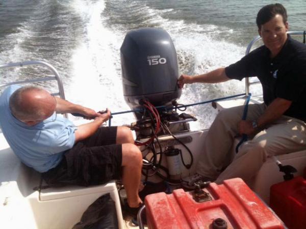 WRAL photographer Greg Clark and reporter Cullen Browder steer a boat's engine while covering Hurricane Irene in August 2011.
