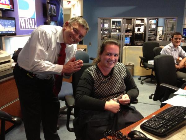 WRAL chief meteorologist Greg Fishel thanks assignment editor Kelly Riner as she sews on his button that popped off during a newscast on Friday, Dec. 14, 2012.