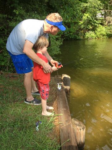 Julia Sims' husband teaches their son to fish.