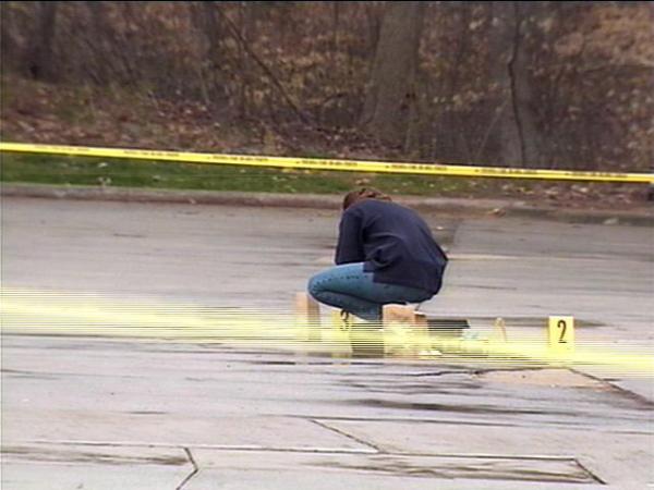 An investigator collects evidence in the parking lot at the Woodcreek Apartments.(WRAL-TV5 News)