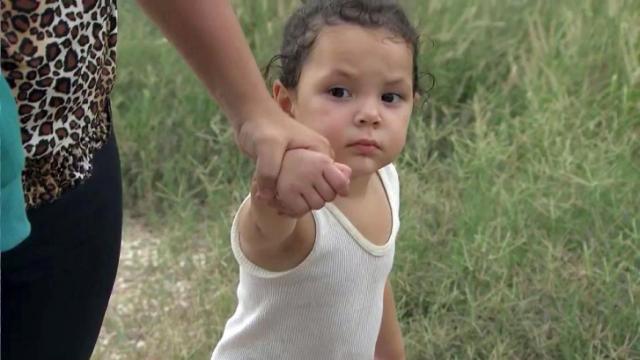 A woman and a child cross the border from Mexico to the U.S. 