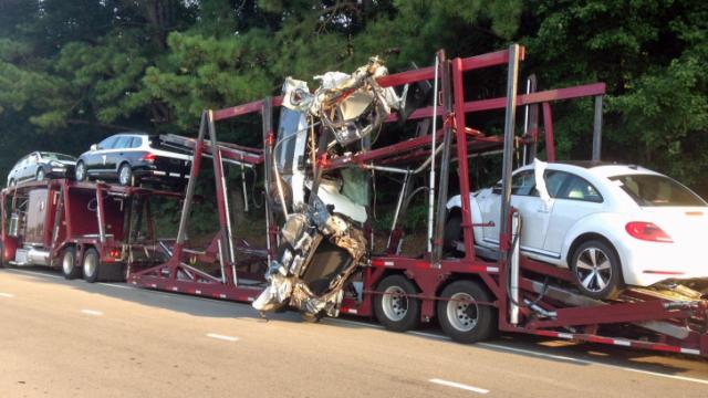 Tractor-trailer carrying cars hits train trestle in Apex