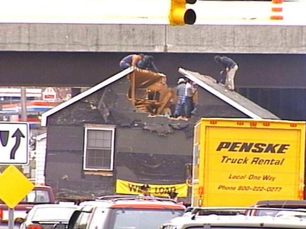 As traffic backed up, the house movers took chainsaws in hand to get under the overpass.(WRAL-TV5 News)