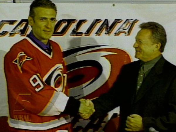 Ron Francis shakes hands with Jim Rutherford after signing a contact worth about