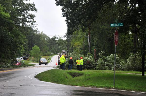 The rain in Durham is weakening the soil near the roots of the trees.  The tree fell, forced the driver off the road and is being suspended by the weakening power lines.