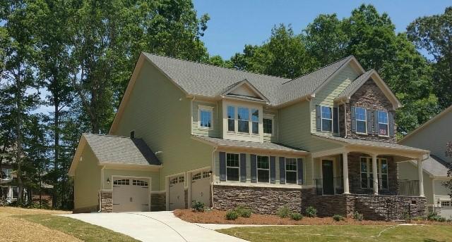 Curb appeal in this home includes the use of stacked stone in harmony with the trending colors of green, gray, and cream, a welcoming front porch, a front door with a window, and side entry single-width garage doors with a third carriage style set-back garage… Wow!