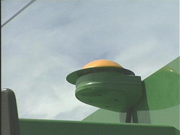 The antenna atop a combine indicates satellite technology inside.