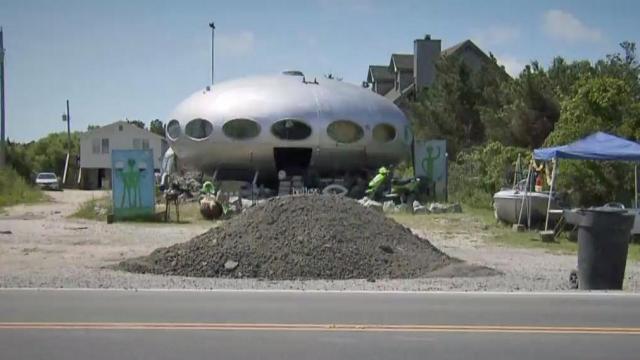 The Futuro House has long been a roadside attraction along the Outer Banks, but a debate between its owner and Dare County is taking the conversation over the out-of-this-world home to new heights. 
