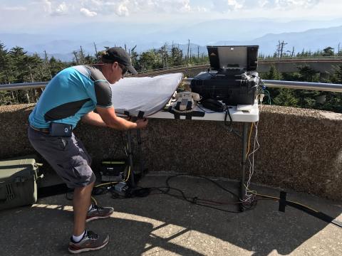 Engineer Tony Gupton secures a sun shade over our communication equipment at Clingmans Dome, including a cell booster and two different satellite phone systems.