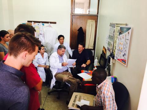 Medical staffers huddle with a Ugandan patient.