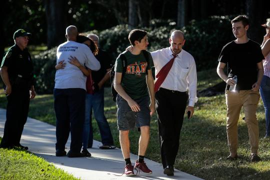Students and parents embrace after the mass shooting at the Marjory Stoneman Douglas High School in Parkland, Fla., Feb. 14, 2018. At least 17 people were killed Wednesday at this school about an hour northwest of Miami, law enforcement officials said. A suspect, a former student, is in custody. (Saul Martinez/The New York Times)