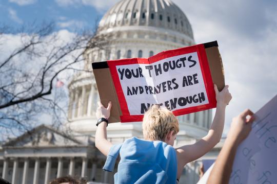 A student protester holds up a sign saying "Your thoughts and prayers are not enough” during a protest outside the Capitol building in Washington, Feb. 21, 2018. Under mounting pressure to take action after the nation’s latest school shooting massacre, Trump planned Wednesday to sit down with about 20 parents and students from the high school in Parkland, Fla. where a gunman killed 17 people last week. (Erin Schaff/The New York Times)