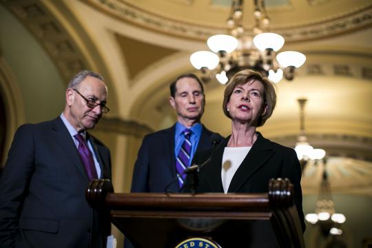 Sen. Tammy Baldwin (D-Wis.) speaks to reporters on Capitol Hill in Washington, March 6, 2018. The Senate took a big step toward approving the first significant legislation to relax some post-crisis financial rules on Tuesday, creating a rift between moderates and progressives in the Democratic party. From left: Senate Minority Leader Chuck Schumer (D-N.Y.), Sen. Ron Wyden (D-Ore.), and Baldwin. (Al Drago/The New York Times)