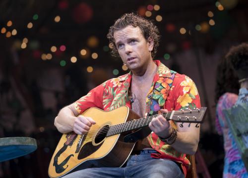 Paul Alexander Nolan in the musical "Escape to Margaritaville" at the Marquis Theater in New York, Feb. 15, 2018. Set at a rundown Caribbean hotel, the Jimmy Buffett jukebox musical follows an uptight environmental scientist and her gal-pal on vacation at a rundown Caribbean hotel, where they meet a singing beach-bum and a dim but sweet bartender. (Sara Krulwich/The New York Times)