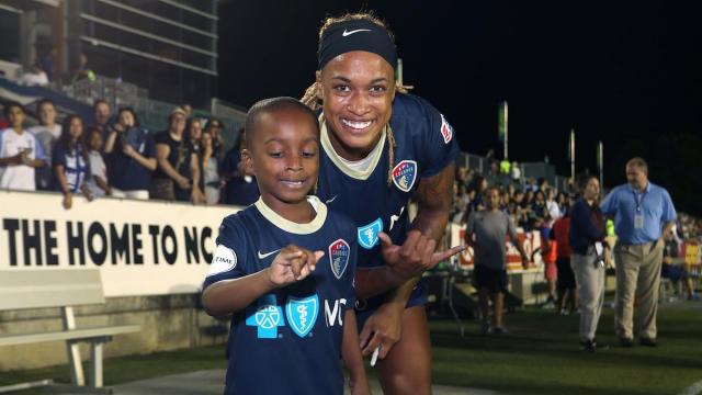 NC Courage player, now World Cup champion, celebrates win on the field with her son