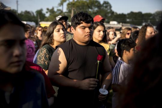 Abel San Miguel, 15, holds a rose at a vigil for victims of a school shooting that left 10 dead in Santa Fe, Texas, May 18, 2018. A 17-year-old student armed with a shotgun and a .38 revolver opened fire on his fellow students at Santa Fe High School, before surrendering himself, authorities said. (Ilana Panich-Linsman/The New York Times)