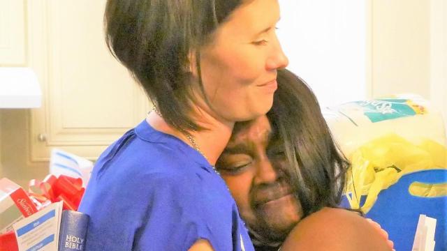 Katie Page shares a hug with new homeowner, Paditra Carlton