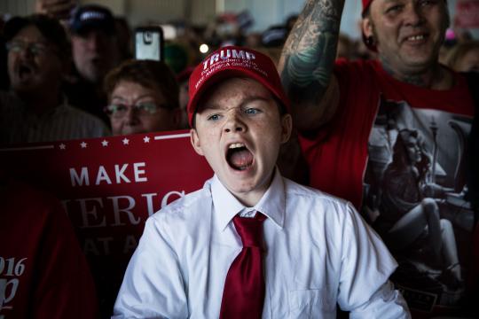 FILE -- With his father beaming behind him, Jaden Rams chants jeers during a campaign rally for then-candidate Donald Trump in Grand Junction, Colo., on Oct. 18, 2016. Then as now, the crowds took their lead from Trump and directed their hatred at the press. (Damon Winter/The New York Times)