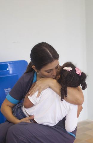 A therapist gives some love to one of the orphans at Casa Providencia