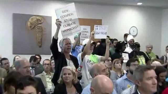 Cooper rolls out climate plan; protesters call it 'sham'