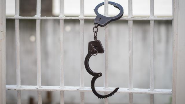 Handcuffs on prison bars