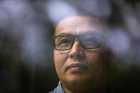 Ye Tun, a technician at Duke University, poses for a portrait in his home in Chapel Hill, NC. Tun immigrated from Burma in 1997. Photo by Nathan Klima.