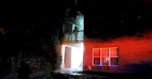 A firefighter sprays down a deck that caught fire at an apartment in Holly Springs Saturday morning.