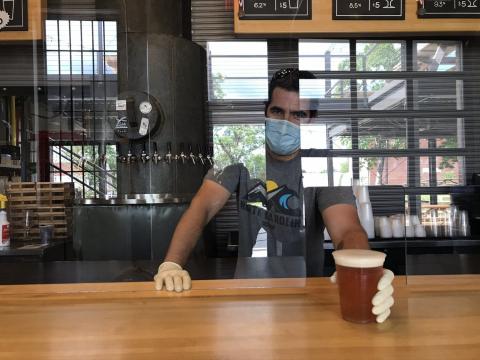 Ponysaurus Brewing has reopened with new safety precautions, including glass around the taproom bar, in the wake of COVID-19. (Courtesy of Ponysaurus)
