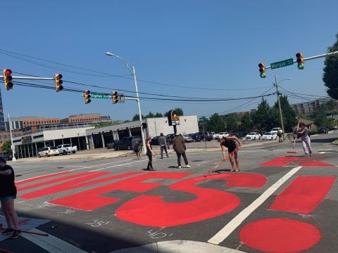 A group of essential workers paints "Black Lives Matter" at the intersection of Morgan St. and Riggsbee Ave. in Durham