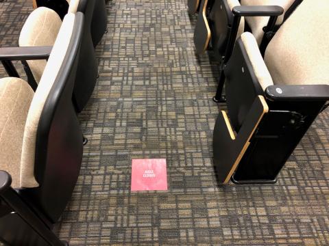 Some aisles are closed in auditorium settings and stickers tell students where to sit to keep their distance.