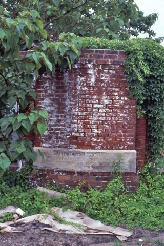 The corner stone of the old Raleigh & Gaston roundhouse, hidden in the weeds near Seaboard Station in1986. (Photo courtesy of Brian Ezzelle) 