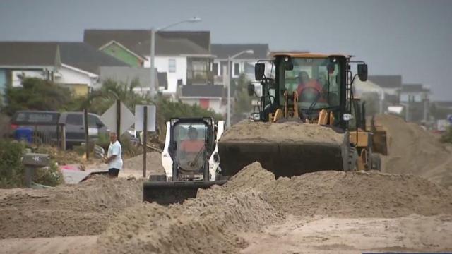 Neighborhoods still working to clear all that sand piled up by Isaias