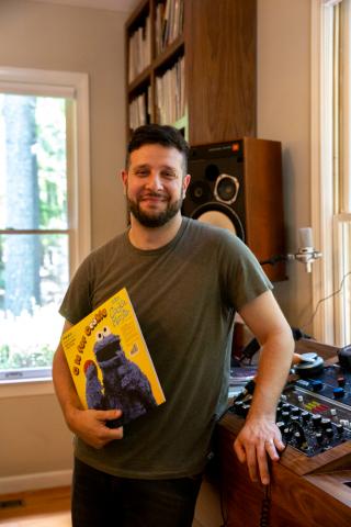 Ben Alschuler, 38, smiles with one of his first ever vinyls “C is for Cookie”, a collection of popular Seseme Street songs. Though Alschuler did not start collecting until he was in high school, he grew up in a home that had vinyl and enjoyed listening to records as a kid on his Fisher Price record player. (Photo by Elizabeth Ranatza)