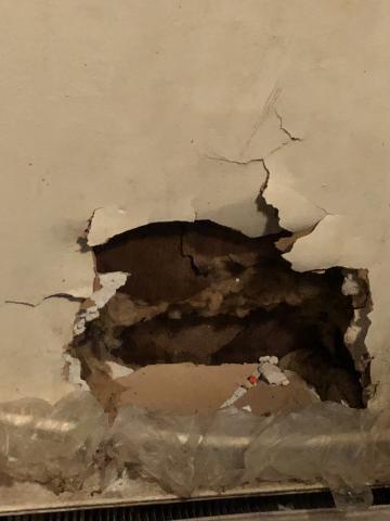 A hole in the wall of Robinson's apartment. The children described roaches crawling out of this hole.