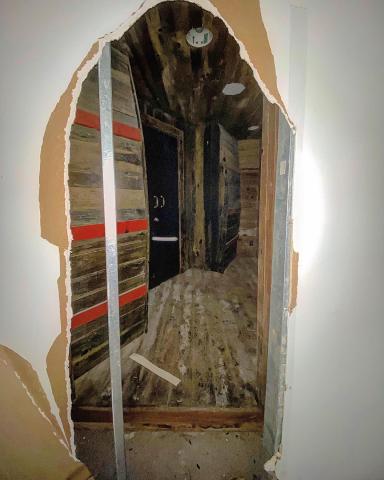 A hole was knocked into the drywall, revealing the entrance to the historic tavern.