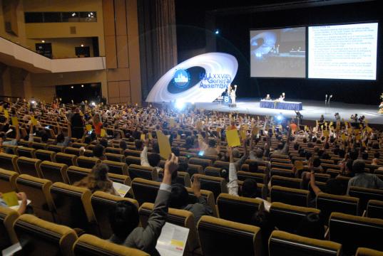 Members of the International Astronomical Union vote on resolutions at the 2006 General Assembly Meeting