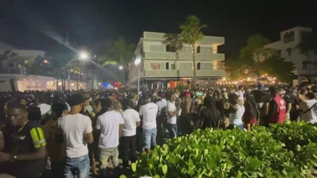 Crowds disperse as Miami Beach police break up huge crowd to enforce curfew