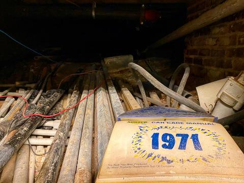 Peeking inside a hidden tunnel in the Temple Theater changing room, which reveals an old manual from 1971. 