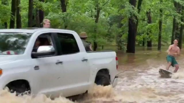 Alabama watersports: Young man surfs through flood waters