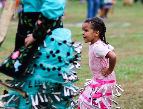 A young girl dances in her jingle dress at Raleigh's first intertribal powwow opening ceremony. 