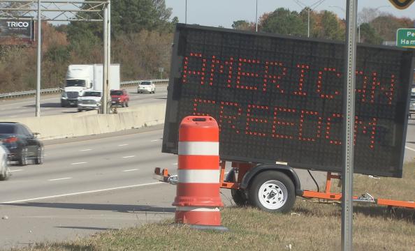 Daniel Cook places large LED sign on the side of I-40 to display the message "American Freedom"