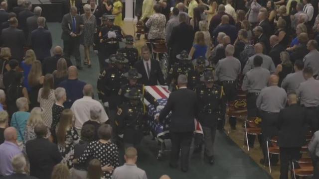 Emotional: Fellow law enforcement officers carry flag-draped casket of fallen Wayne County deputy