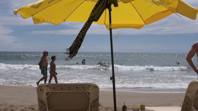 Chairs and umbrellas on the Sant Sebastià beach in Sitges, Spain, in August 2022. Sitges, just south of Barcelona, has 17 beaches and a quiet, timeless charm that draws all kinds of visitors to return year after year. (Maria Contreras Coll/The New York Times)