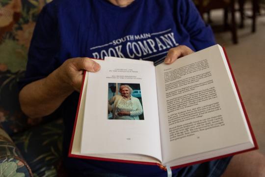 Ruth Moose shows off a book gifted to her by the son of a former student, Helen Harris, at her home in Albemarle, N.C., on September 7, 2022. According to Moose, Harris continued writing long after taking the class. Her son had returned to tell Moose, later going on to collect and bind his mother's writing in a book.