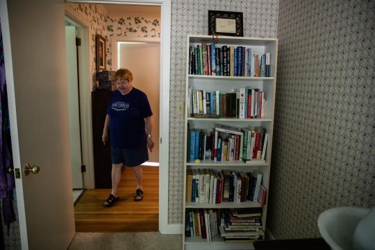 Ruth Moose walks into her bedroom during a tour of her home in Albemarle, N.C., where she keeps one of many bookshelves.