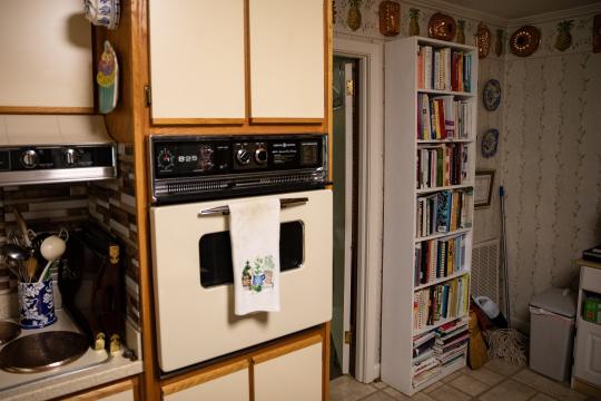 Ruth Moose keeps a healthy collection of books across her house, including a bookshelf in the kitchen laden with cookbooks.