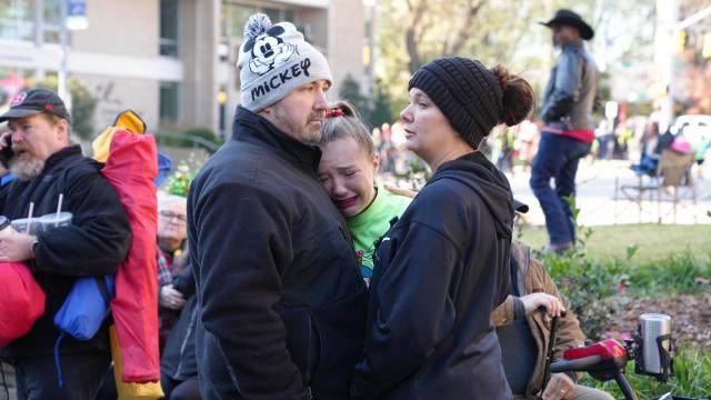 Parade goers react after a young girl was hit by a pickup truck in the Raleigh Christmas Parade.  (Photo by Billy Liggett)