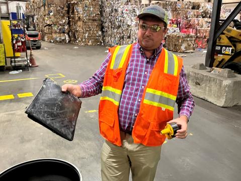 Sonoco Raleigh Plant Manager D.J. Muminovic holds a rechargeable battery and a laptop pulled from the recycling facility's line. Rechargeable lithium ion batteries included in a wide range of electronics can explode when crushed and should not be placed in curbside recycling bins.