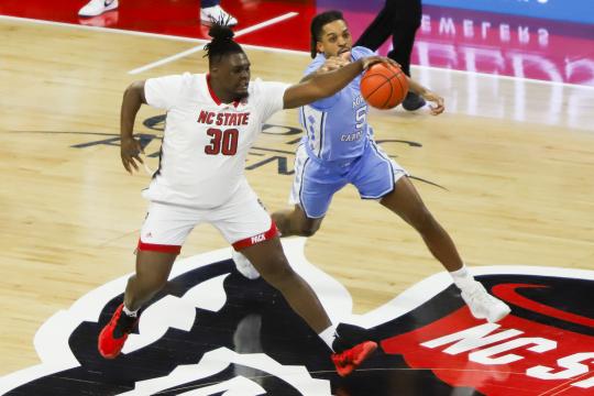 Armando Bacot (5) and DJ Burns Jr. (30) go for a loose ball. North Carolina defeated NC State by a score of 67-54 at PNC arena in Raleigh, NC on January 10, 2024. (Jerome Carpenter/WRAL Contributor)