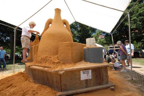 Ed Moore leads a team of sculptors in creating a sand sculpture in Moore Square.